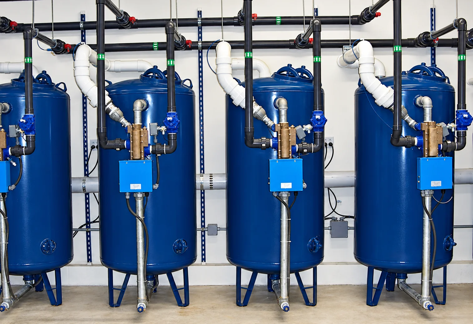 Blue media filter vessels with valves and overhead piping in a high-purity water system