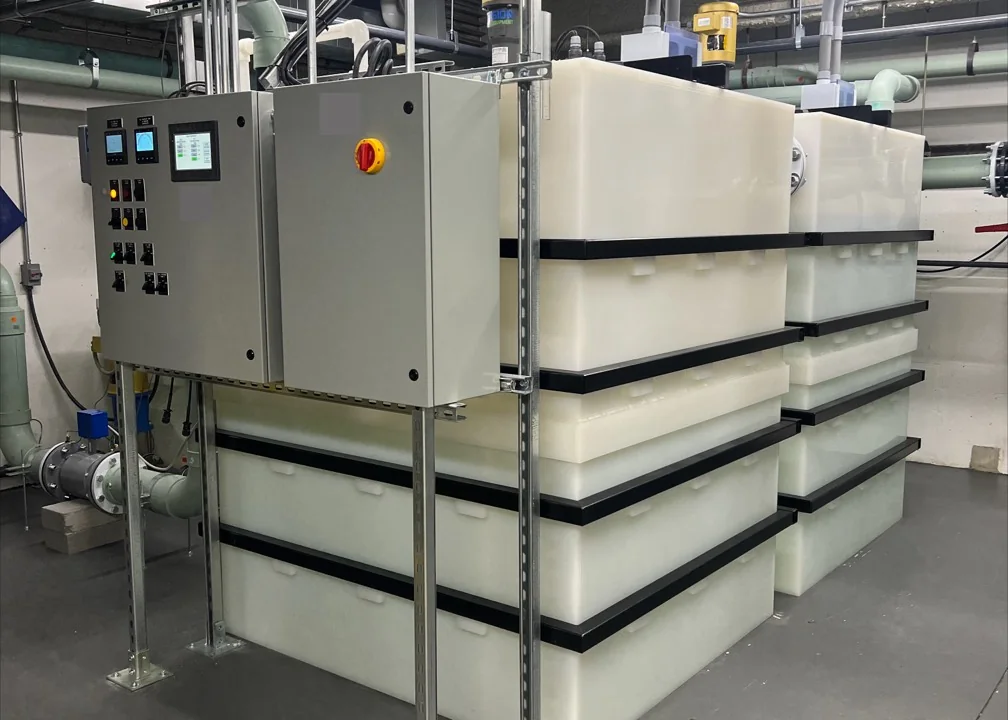 Two-tank industrial wastewater treatment system with a control panel and connecting pipework